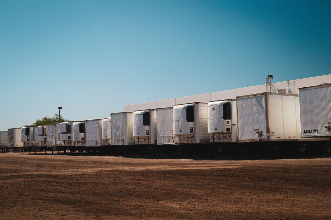 Row of refrigerated reefer trailers parked at a distribution yard, illustrating temperature-controlled cold chain shipping capability